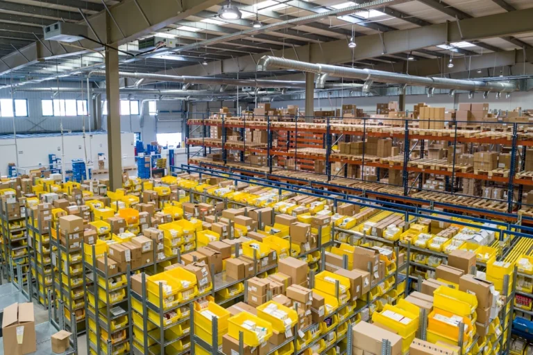 Logistics warehouse with inventory management screens showing AI demand forecasting dashboard — machine learning predicts fr