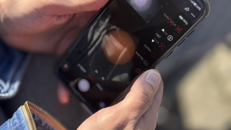 Person using a smartphone camera app outdoors, representing AI visual search