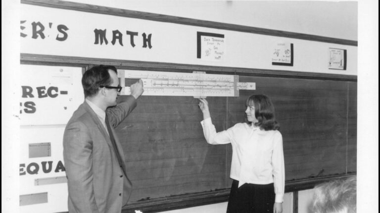 Teacher and student working through a math equation on a chalkboard