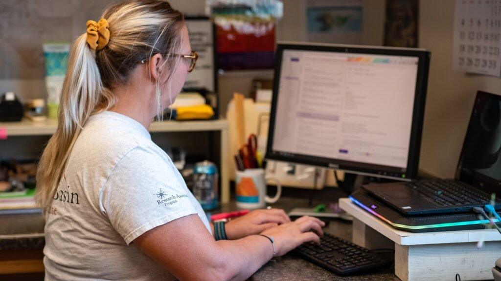 Person working at a desk checking email on a computer