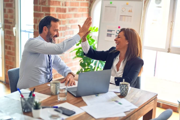 Small business owner using Claude AI on laptop for customer emails website copy social media and business documents 2026
